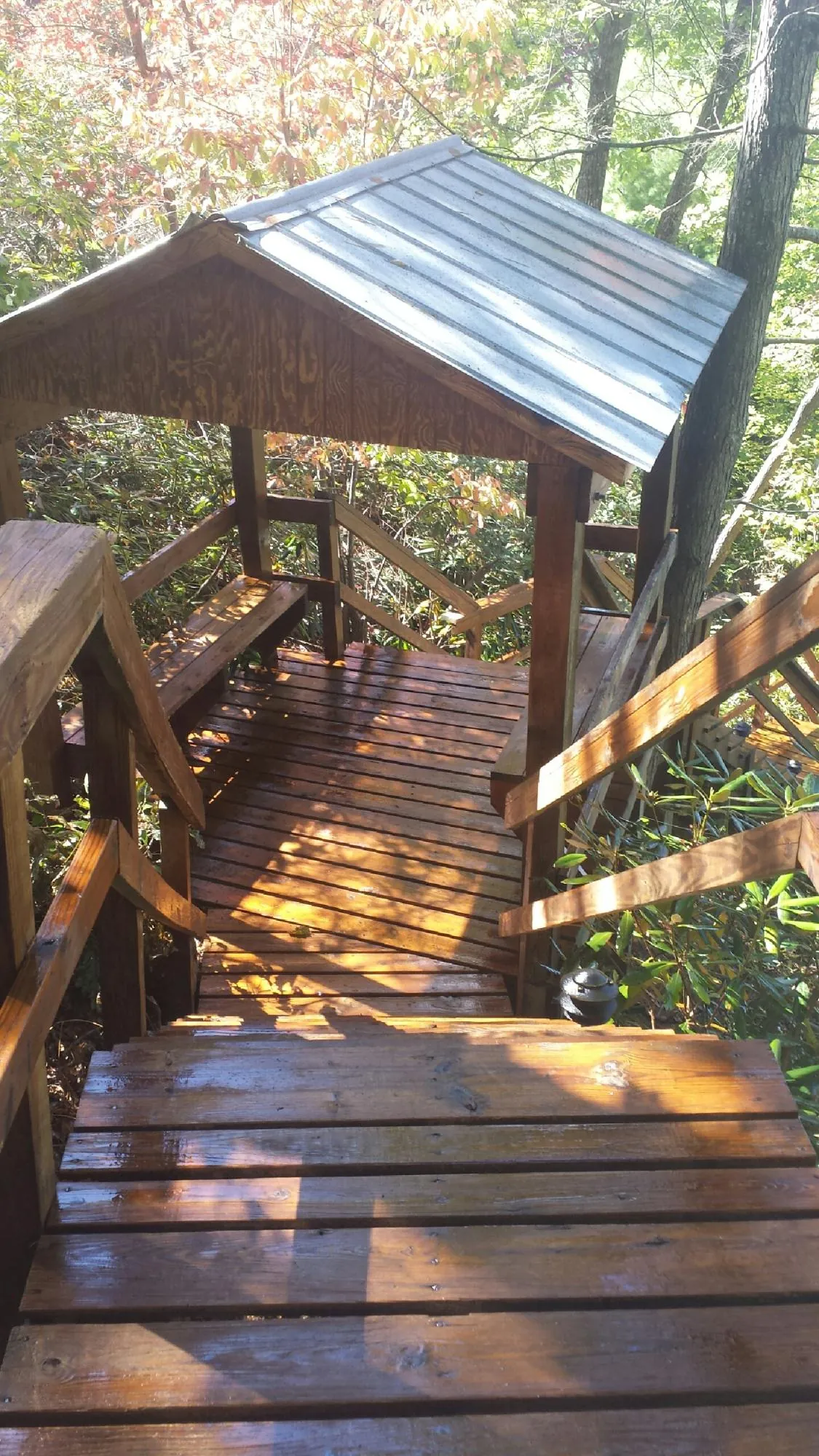 Freshly stained wood walkway and covered shelter with a metal roof in Littlerock
