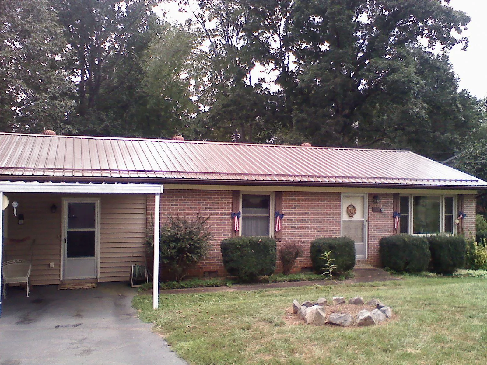 Bronze metal roof and carport on a brick ranch home — Roof Repair work by our crew in Littlerock